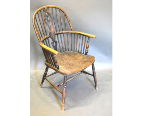 An Early 19th Century Elm Wheel And Stick Back Windsor Armchair with a panel seat raised upon turned legs with stretchers 