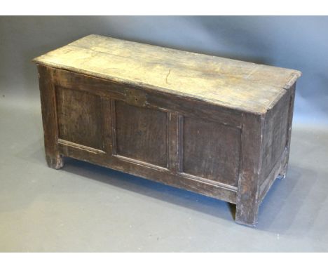 An 18th Century Oak Coffer, the hinged plank top above a three panel front flanked by stiles, 114 cms wide x 47 cms deep x 56