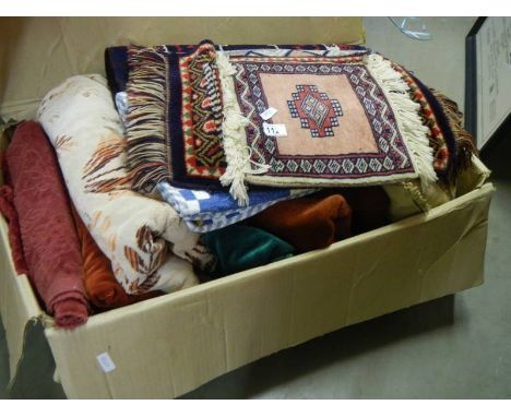 A box of curtaining and fabric pieces plus various rugs and small patchwork quilt.
