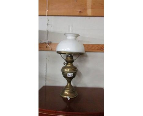 A brass oil lamp with shade.