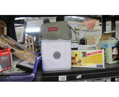 A shelf of miscellaneous items including calculators, air purifier etc.