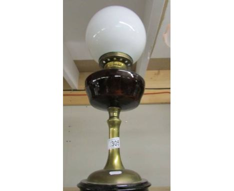 A brass oil lamp with glass font.
