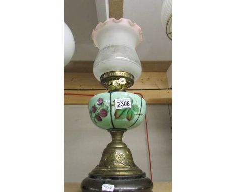 A brass oil lamp with hand painted glass font and later shade.