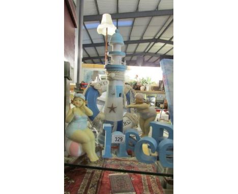 A mixed lot of seaside ornaments including light house, figures etc.,