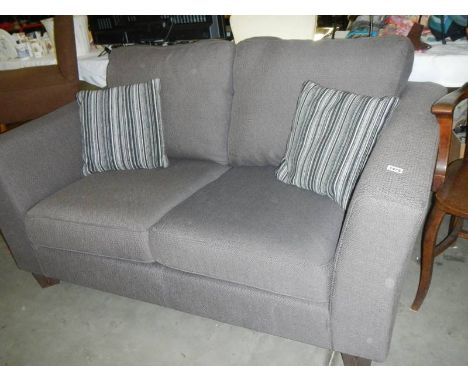 A grey fabric 2 seater sofa with 2 matching cushions