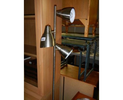 A brushed stainless steel floor standing lamp.