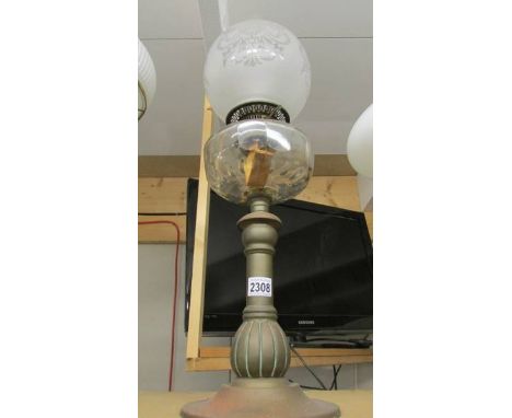 A brass oil lamp with glass font and etched shade.