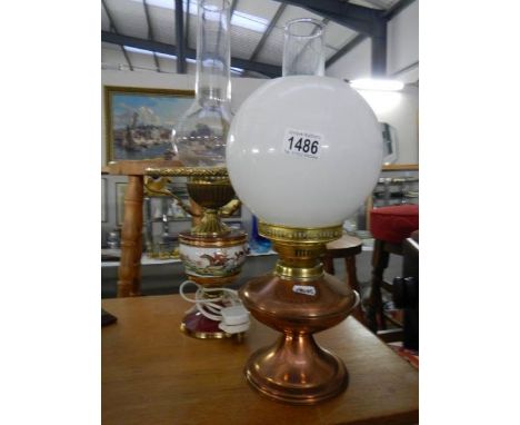 A copper oil lamp with shade and chimney and a pottery electric lamp with hunting scene decoration