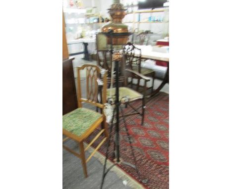 A wrought iron and brass standard oil lamp.