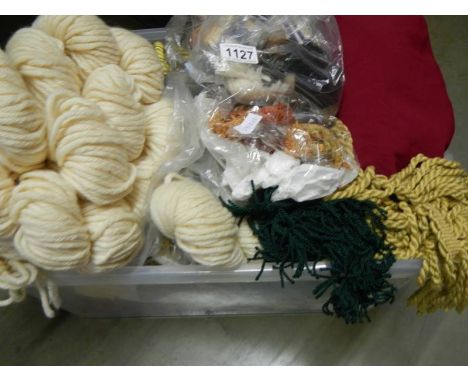A box of tapestry threads, fringing and textile pieces.