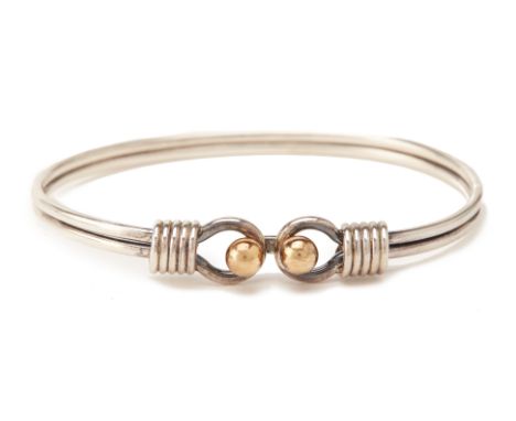 A TIFFANY &amp; CO SILVER AND GOLD BANGLE
The silver bangle with yellow gold ball hook clasp, marked 'Tiffany &amp; Co 925 75