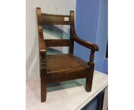 An oak child's commode chair