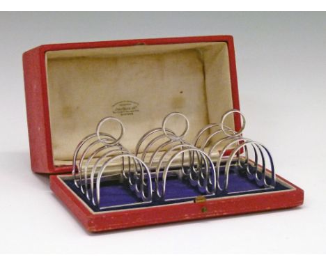 Set of three George V silver four division toast racks, each having a circular loop handle, makers Wilkinson & Sons, Birmingh