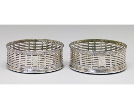 Pair of George III silver coasters, each having a bead border, pierced decoration between engraved bands and small inset butt