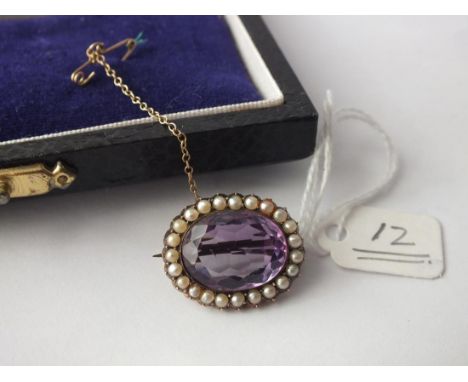 An antique oval amethyst and pearl bordered brooch set in 9ct.         