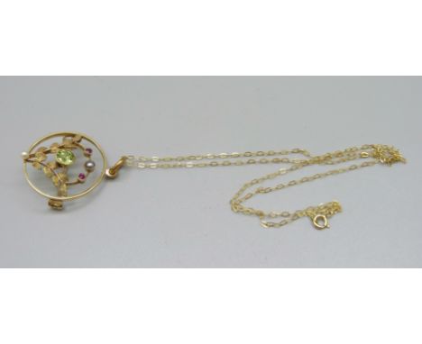 A vintage 15ct gold, peridot, ruby and pearl pendant/brooch and fine 9ct gold chain, 3.9g 