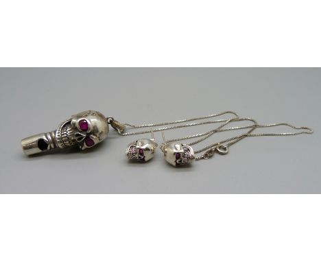 A silver skull whistle pendant with ruby eyes on a silver chain and matching earrings 