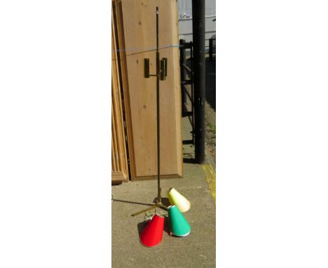 A brassed standard light with three lamps, conical cloth shades 
