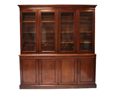 A Victorian mahogany library bookcase,the moulded cornice above two pairs of glazed doors, enclosing three sets of shelves, r