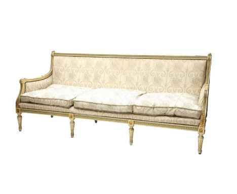 A French-style painted and parcel-gilt sofa, 20th century, upholstered in floral fabric, with acanthus carved detail and stop