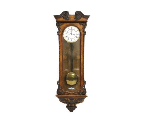 A walnut Vienna wall clock,19th century, the case with carved foliate scrolls and beaded mounts, the enamel dial with a subsi