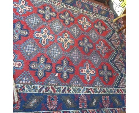 A Persian carpet with multi-coloured medallions on a red ground, with multi-coloured geometric borders, 285 x 190cm 