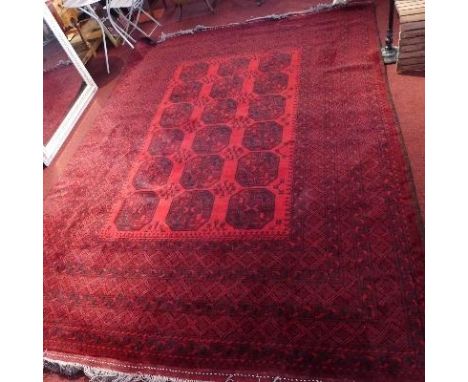 A large Afghan carpet, with elephant pad motifs, on a red and black ground, contained by repeating geometric borders, 348x248