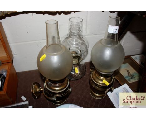 Two brass gimbal oil lamps; and a glass oil lamp