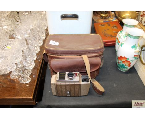 A Ricoh caddy camera in case; and a Bell &amp; Howell auto set cine camera with tripod and accessories in carrying case 