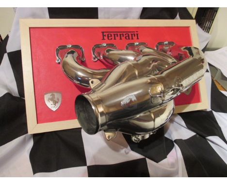 A polished exhaust manifold from a 2011 Ferrari V8 (056) F1 engine. Mounted on a wooden base complete with a Certificate of A