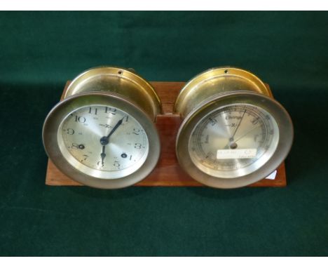 Combination brass cased barometer and clock, the dials inscribed Howard Millar,  raised on walnut plinth