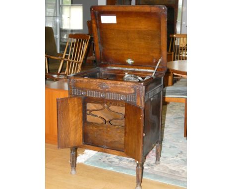 A wind-up record player in large ornate cabinet on legs,  includes handle and some needles. 3 needle holders and space for re