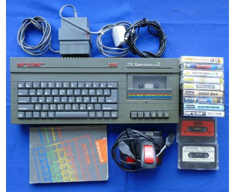 A Spectrum +2 games console (grey) S. No U-013334 together with power supply unit, TV lead, joystick, manual, and a selection