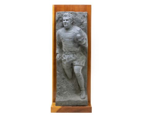 Football: A black granite cast maquette depicting Dave Mackay holding a football coming out of a rock. This maquette is a sma