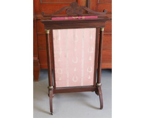 A mahogany glued Empire fireplace screen, ca. 1815. Ornate crowning, columns with bronze capital and base as styles, resting 