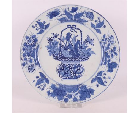 A blue/white porcelain dish, China, Kangxi, early 18th century. Blue underglaze decor of a basket with flowers on the shelf, 