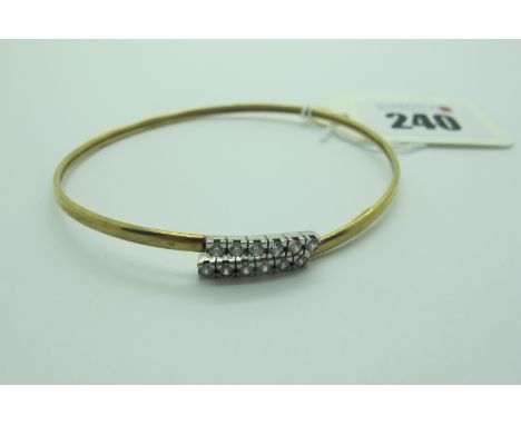 A Modern Bangle, of crossover design to the front, with inset highlights, stamped "Italy 9KT" (3.6grams). 
