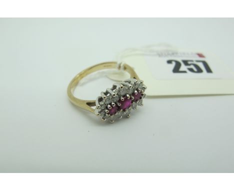 A Modern Ruby and Diamond Cluster Dress Ring, claw set throughout, stamped "375" ".40" (finger size O). 