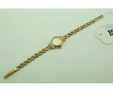 Polaris; A Ladies Wristwatch, the circular signed dial with line markers, in plain case, with textured details, stamped "18K 