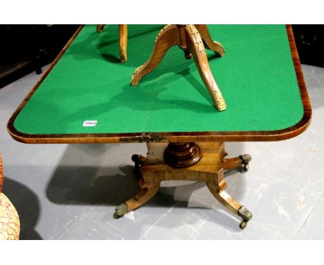 Regency fold over card table in rosewood, raised on quadrifoil support terminating in brass castors, relaid green baize inser