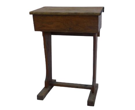 A 20thC oak school desk, with recess with inkwell, the sloping hinged top enclosing a vacant interior, on shaped end supports
