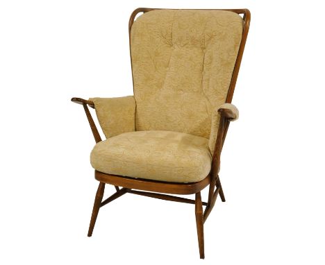 An Ercol elm stick back armchair, model 1913, with loose seat, back and arm cushions, on turned legs united by a H stretcher.