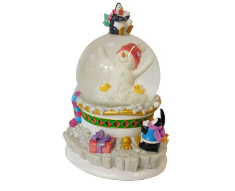 A Waterford Holiday Heirlooms musical globe, decorated centrally with a snowman in a bathtub surrounded by two penguins throw