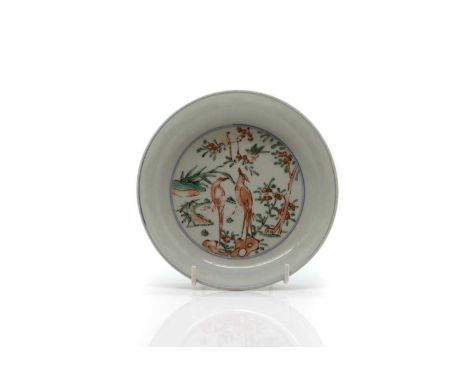 A Chinese wucai dish, the rounded sides rising from a circular foot, painted in the Wanli style, of two peasants on a rock, s