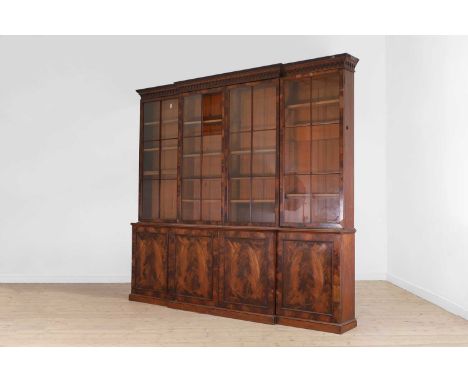 A flame mahogany library bookcase,  first half of the 19th century, of breakfront outline, with glazed doors enclosing shelve