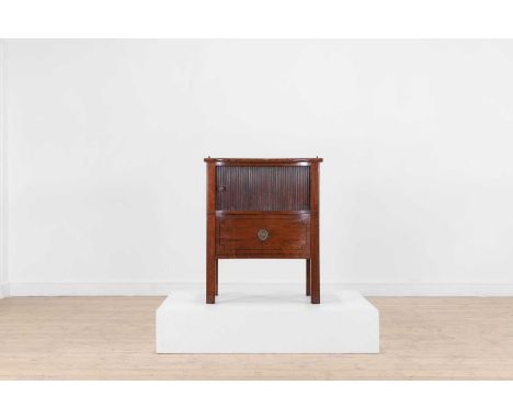 A George III mahogany bedside commode, late 18th century, of concave shape with a tambour slide above a leather-lined drawer,