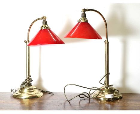 A pair of arched brass reading lamps, 20th century, adjustable height, with red glass conical shades, 50-58cm hightogether wi