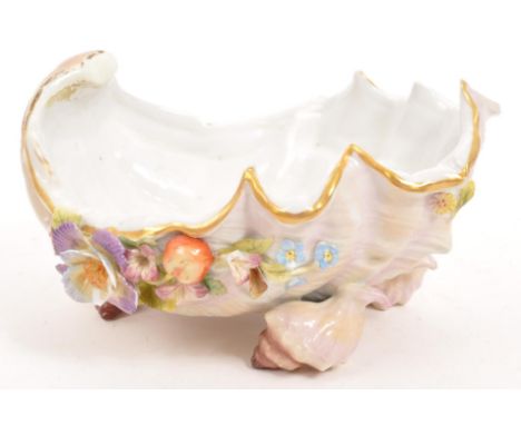 A 19th century Meissen ceramic shell bowl. Having a purple / white ground with floral and fruit protruding pattern, raised on