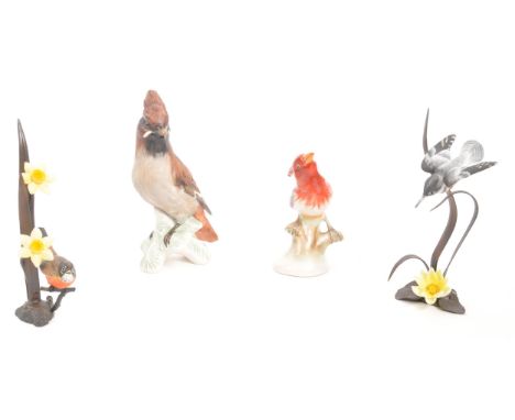 Goebel - A collection of four bird figurines comprising of a china Goebel bird figure, two wrought iron bird figures amongst 