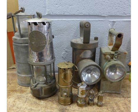 Four miner's lamps including The Protector Lamp &amp; Lighting Company Type 6 and four miniature miners lamps 
